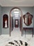 The luxurious apartment hall in a classic style with brown furniture and blue walls. Decorative niches in the wall with a