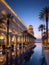Luxurious asian style palace and swimming pool with palm trees in the evening illumination on the seashore