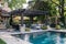 Luxurious backyard with pool and lounge area under pergola.