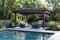 Luxurious backyard with pool and lounge area under pergola.