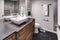 Luxurious bath with grey vanity cabinet.