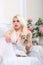 Luxurious blonde woman in a white dress with a dog pekingese