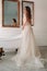 A luxurious bride in a wedding dress in the morning in her interior