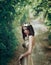 Luxurious brunette girl posing in a golden steel dress and wearing a crown with leaves. Gothic Queen Autumn in the