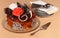 Luxurious cake with chocolate decorations on large platter, small saucers and spoons, on beige
