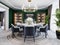 Luxurious dining room in a large house, with a round table for six people. Leather chairs, marble countertops, TV unit, sideboard