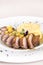 Luxurious dish with slices of duck breast,  pineapple pieces,  sweet sauce,  with potato puree and parmesan