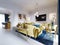 Luxurious fashionable living room with yellow upholstered furniture and blue carpet and decor, Yellow console with decor
