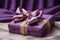 Luxurious gift tied with satin ribbon with bow on background of purple fabric. Beautiful drapery. Gift for any holiday