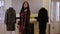 A luxurious girl with long hair tries on a fur coat in a women\'s clothing store.