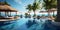 Luxurious hotel pool on vacation and umbrella loungers next to the beach and palm trees under blue skies