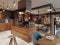 Luxurious kitchen modern style with wooden contemporary furniture and island with hood. Burgundy gray walls, black granite