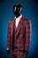 Luxurious men`s burgundy three-piece suit, white shirt on dummy or mannequin on blue background