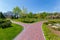 Luxurious park with trimmed lawn and stone paved paths