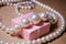 Luxurious pearl jewelry on a pink box. Snow-white pearls. Bijouterie. Jewelry. Pearl beads. Women`s jewelry.