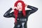 Luxurious plus size woman with Asian face, bright makeup and red curly hair posing in shiny closed long black dress on white backg