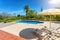 Luxurious pool in the garden of a private villa, hanging chair with pillows for leisure tourists, in summer. Portugal