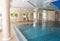 Luxurious pool interior design, sunlight from panoramic Windows, stylish columns and turquoise water
