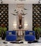 Luxurious reception hall design with a blue armchair and console and a wall of mirrors with 3d panel, light wood palm trees