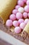 Luxurious round dessert with pink chocolate spheres. Yellow mousse birthday cake with multicoloured sweet sugar balls