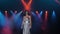 A luxurious singer enters the stage in the light of one white spotlight.