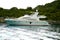 A luxurious white yacht stands in a bay on an island.