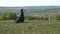 A luxurious woman in a black board walk over the meadow