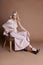 luxurious woman in a dress sitting on a chair. Autumn collection of women clothing. Fashion blonde in a long beautiful dress
