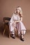 luxurious woman in a dress sitting on a chair. Autumn collection of women clothing. Fashion blonde in a long beautiful dress