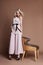 luxurious woman in a dress sitting on a chair. Autumn collection of women clothing. Fashion blonde in a long beautiful dress