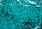 Luxury background made of turquoise sequins. Shiny fabric texture