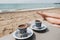 Luxury beach vacation for couple in Turkey. Two cups of Turkish coffee, female legs, sand and Mediterranean sea in background.