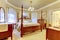 Luxury bedroom with high pole carved wood bed, nightstand and va