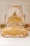 Luxury bedroom in light colors with golden furniture details. Big comfortable double royal bed in elegant classic