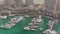 Luxury boats and yachts docked in Dubai Marina aerial timelapse.