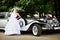 Luxury bride in wedding dress about limousine