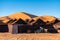 Luxury brown tent camp in Sahara Desert Merzouga, Morocco on a sunny day with sand dunes on background