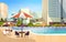Luxury city hotel swimming pool resort with umbrellas desks and chairs restaurant furniture around summer vacation