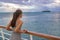 Luxury cruise vacation woman looking at French Polynesia motu island from boat deck at sunset. Elegant tourist relaxing