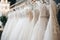 Luxury elegant bridal dress on hangers. Beautiful white wedding dresses hanging on hanger in bridal shop boutique salon