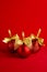 Luxury fashion red christmas balls with gold bow standing on deep silk red background, copy space, vertical. New year background.