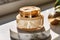 Luxury gold face cream jar on luxurious marble under golden sunlight at spa, beauty and skincare product, generative ai