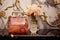 a luxury handbag placed next to a vintage perfume bottle on a marble table