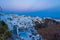 Luxury holiday resort clifftop villas overlooking the Caldera on twilight Santorini Greece