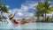 Luxury hotel swimming pool woman relaxing in lounging chair on summer vacation