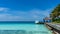 Luxury island in Maldives, wooden jetty into blue tropical sea. Blue sky, sunny day in Maldives resort.