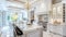 a luxury kitchen adorned with white cabinets, a marble island countertop, and a dazzling chandelier suspended above the