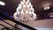 Luxury large crystal chandelier hanging in the Palace. Vintage lighting lamps with light bulbs and a lot of pendants
