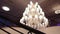 Luxury large crystal chandelier hanging in the Palace. Vintage lighting lamps with light bulbs and a lot of pendants