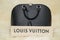 Luxury Louis Vuitton ALMA PM handbag on the table